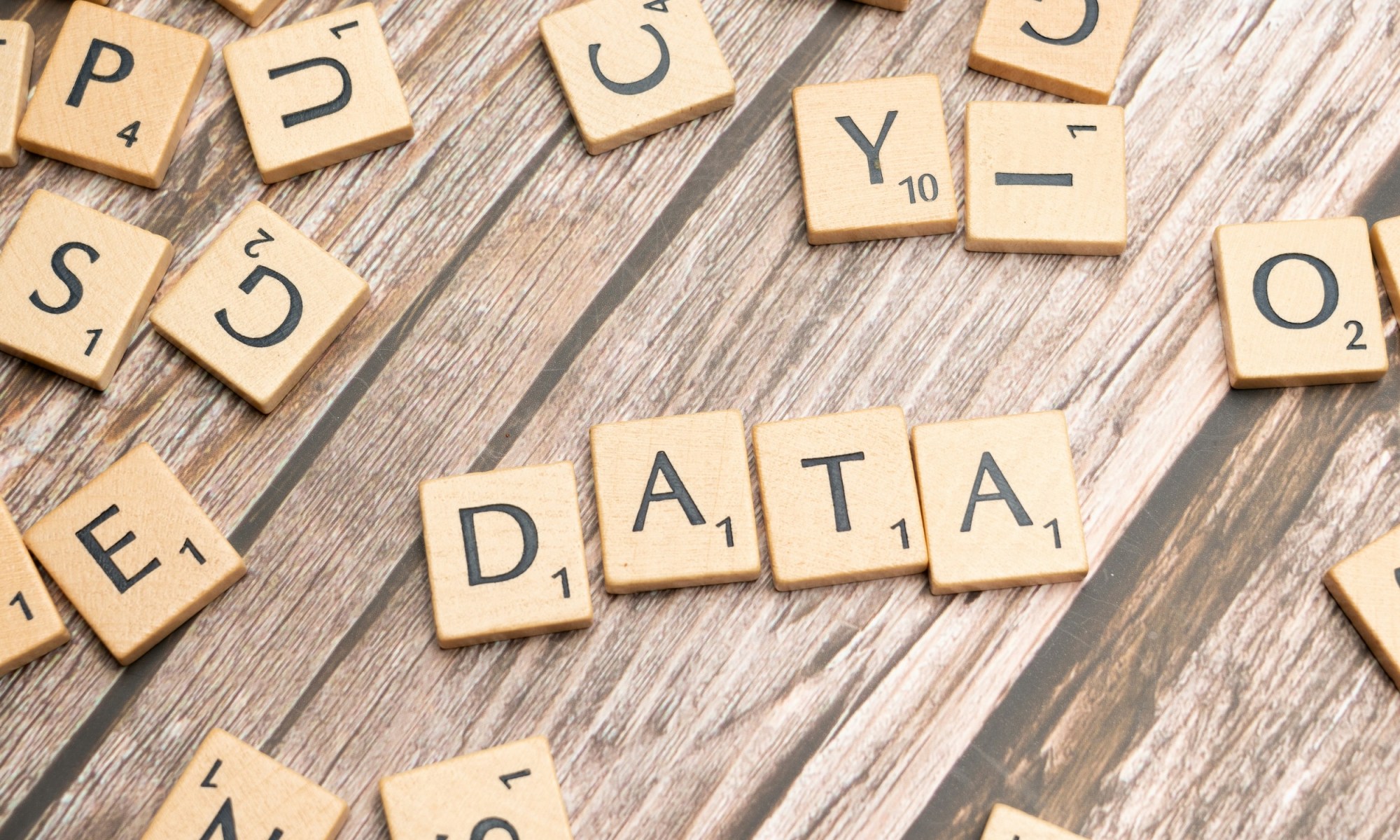 Scrabble letter pieces that form the word DATA