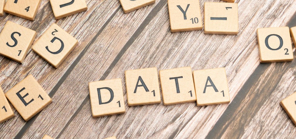 Scrabble letter pieces that form the word DATA
